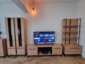 a living room with a television and wooden cabinets at Apartman Lovre in Zadar