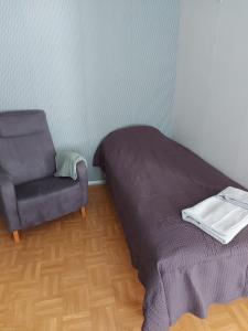 a bedroom with a bed and a chair at Mikko's house in Pori