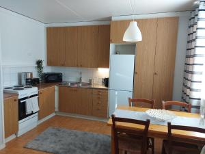 a kitchen with a table and a white refrigerator at Mikko's house in Pori