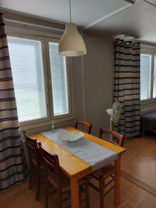 a dining room table and chairs in a room with windows at Mikko's house in Pori +4 photos