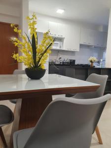 a kitchen with a table with a potted plant on it at Apto com armários e eletrodomésticos NOVOS in Cuiabá