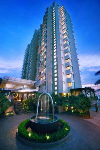 Golden Tulip Balikpapan Hotel & Suites في باليكبابان: مبنى كبير أمامه نافورة