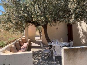 una mesa y sillas sentadas bajo un árbol en Villa Brachera, en Spetses