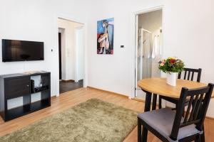 ein Wohnzimmer mit einem Tisch und einem TV in der Unterkunft Studio apartment Financial Park Belgrade in Belgrad