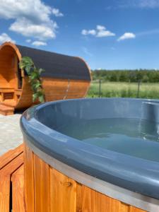 a hot tub sitting on top of a deck at Leśna Osada -Dominikowo -sauna , balia in Dominikowo
