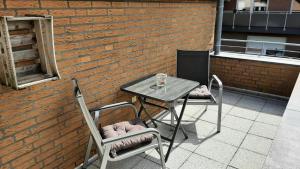 une table et deux chaises assises sur une terrasse dans l'établissement Ferienwohnung Onkel Willi, à Telgte
