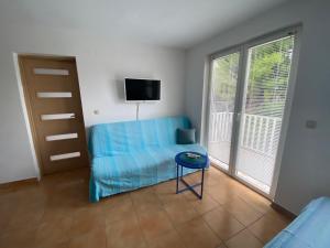 ジュリャナにあるApartman Anaのベッドルーム(青いソファ、椅子、テレビ付)