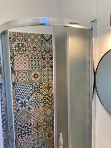 a shower in a bathroom with tiles on the wall at Apartamenty przy Starym Rynku in Poznań