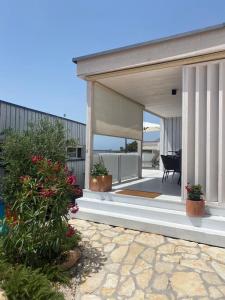 a porch of a house with potted plants on it at BUQEZ ECO RESORT - Beach Villa 37 and 40 in Pakoštane