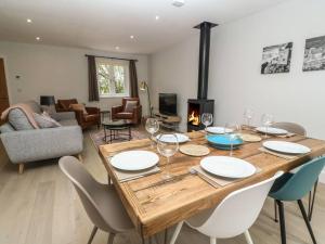 a dining room with a table with chairs and a fireplace at Tinners Rest your comfortable holiday retreat in Lower Boscaswell