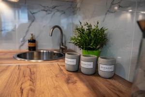 three coffee cups sitting on a counter in a kitchen at Apartamenty Tercet, Apartament Sonata in Ustka