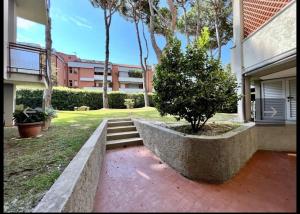 a tree in a stone planter in front of a house at Lido Appartamento Parcheggio Privato 400 mt dal mare in Lido di Camaiore