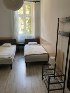 two beds in a room with a window at Apartamenty przy Starym Rynku in Poznań