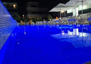 una piscina con iluminación azul en un hotel por la noche en Bunga Bunga Resort Mamaia Nord, en Mamaia Nord – Năvodari
