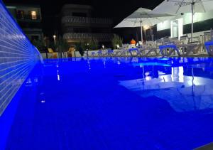 ママイア・ノルドにあるBunga Bunga Resort Mamaia Nordの夜間のホテル内のスイミングプール(青い照明付)