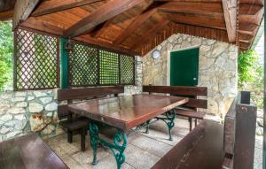 a wooden table and benches on a patio at Apartmani Kraljevica in Kraljevica
