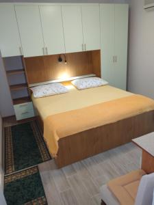 Schlafzimmer mit einem großen Bett und weißen Schränken in der Unterkunft Apartment and rooms Hvar Limoni accessible today in Hvar