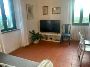 a living room with a television and a table and chairs at Antica Casa Prile in Castiglione della Pescaia