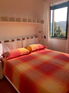 a large bed in a bedroom with a window at Antica Casa Prile in Castiglione della Pescaia