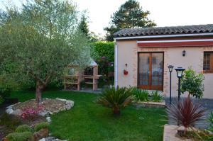 un jardín frente a una casa con una mesa en L'OLIU DE L'OUSTALET en Castelsarrasin