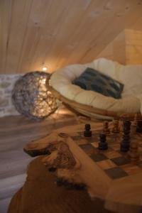 ein Schachbrett und eine Couch in einem Zimmer in der Unterkunft Domaine Moulin de Quincenat Gîte Moulin au Bois Dormant in Champagnat