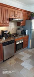 uma cozinha com armários de madeira e um forno com placa de fogão em Suite just over the beach-Adults only em Punta Cana