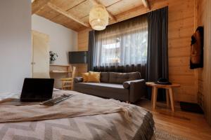 a bedroom with a couch and a bed with a laptop at Biała izba Apartamenty in Szaflary +68 photos