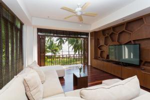 a living room with a white couch and a flat screen tv at Amatapura Beachfront Villa 12, SHA Certified in Ao Nam Mao