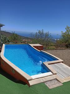 una gran piscina con terraza de madera en un patio en Casa de los abuelos, en Vilaflor