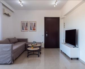sala de estar con sofá y TV de pantalla plana en Apartment Santa Marina 2, en Rodas