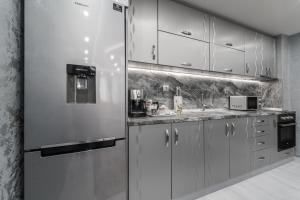 a kitchen with a stainless steel refrigerator at City Apartments - a brand new luxury & comfy. in Asenovgrad