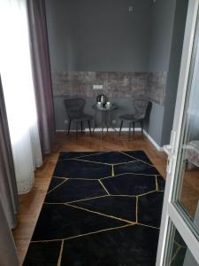 a hallway with a table and chairs and a blue rug at Santorini in Chişinău