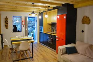 a kitchen and living room with a table and a couch at Casa do Amieiro, Cantinho do Céu in Casal do Rei