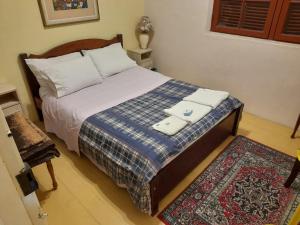 a bedroom with a bed with a blue blanket and a rug at Hostel Pousada Rheingantz Rio Grande in Rio Grande