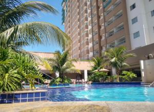ein Swimmingpool mit Palmen vor einem Gebäude in der Unterkunft Resort Olímpia Park 0912 in Olímpia