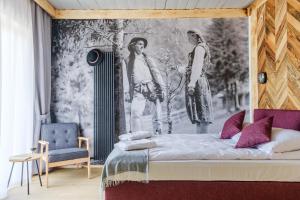 - une chambre avec un lit orné d'une peinture murale dans l'établissement Panocek, à Białka Tatrzańska