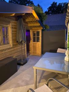 eine Terrasse mit einem Tisch und einem Sonnenschirm in der Unterkunft Bien-être au rendez-vous - Spa Privatif in Blaton