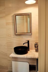 a bathroom with a black sink and a mirror at Santorini in Chişinău