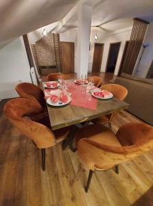 einen Esstisch und Stühle mit Tellern und Gläsern darauf in der Unterkunft Gold Apartment in Strumica