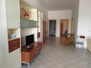 un salon avec une télévision, un canapé et une table dans l'établissement Villa delle Agavi, à Campomarino