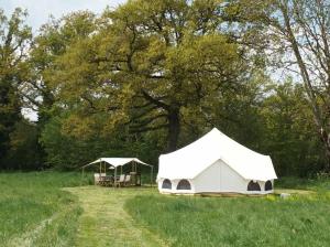 two tents in a field with trees in the background at La Toile sous Les Étoiles in Charron