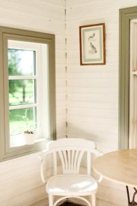 a table and two white chairs in a room with a window at Matsi cottage in Igaküla