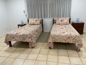 a bedroom with two beds with pillows and a window at Tamborine Accommodation 84 Eagle Heights Road 6 Bedroom 3 Baths Parking Complete Holiday Home in Mount Tamborine