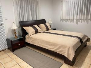 a bedroom with a bed and a nightstand with two lamps at Tamborine Accommodation 84 Eagle Heights Road 6 Bedroom 3 Baths Parking Complete Holiday Home in Mount Tamborine