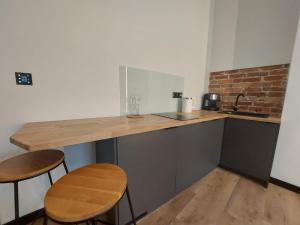 a kitchen with a counter with two chairs and a sink at Sparrow Apartment in Świnoujście