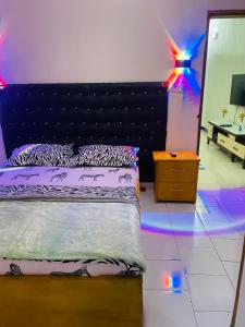 Schlafzimmer mit einem Bett und Beleuchtung auf dem Boden in der Unterkunft Residence SVET in Kribi
