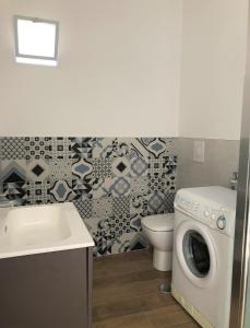 ein Badezimmer mit einer Waschmaschine und einem WC in der Unterkunft Vista Amantea in Amantea