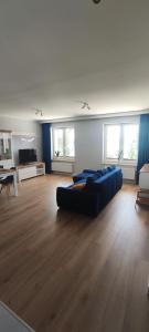 a large living room with a blue couch in it at Apartamenty Przystań in Ełk