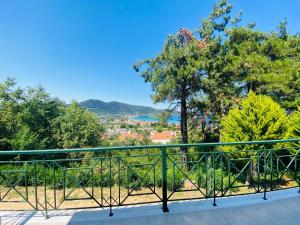 a balcony with a green railing and trees at Villa Vision in Skala Potamias
