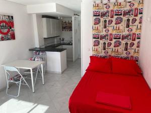 uma cama vermelha num pequeno quarto com uma cozinha em Jupiter Apartment Sea, Pools View em Benalmádena